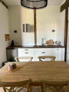 a kitchen with a wooden table and chairs at Peaceful Cottage Near Saint-Savin Abbey in Journet