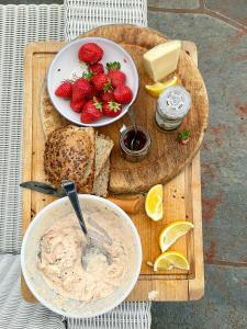 a bowl of dip and a plate of strawberries and cheese at Cabin With Sunset Views And Private Dock in Sandefjord