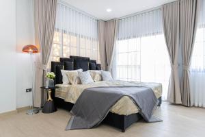a bedroom with a large bed in front of windows at Psalms 23 Residence in Bangkok