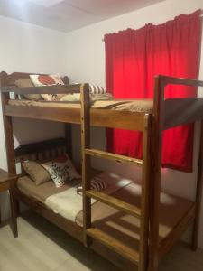 2 stapelbedden in een kamer met een rood gordijn bij Happy Feet Siargao Homestay -General Luna in General Luna +4 foto's