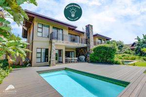 a villa with a swimming pool in front of a house at Baluwatu 10, Zimbali Estate by Euphoric Leisure in Ballito
