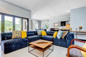 a living room with blue couches and a table at Baluwatu 10, Zimbali Estate by Euphoric Leisure in Ballito