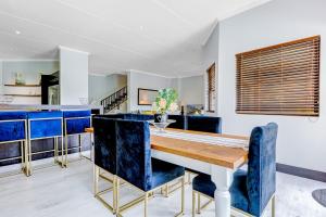 a dining room with blue chairs and a wooden table at Baluwatu 10, Zimbali Estate by Euphoric Leisure in Ballito