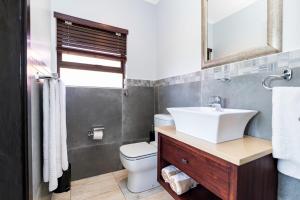 a bathroom with a sink and a toilet at Baluwatu 10, Zimbali Estate by Euphoric Leisure in Ballito