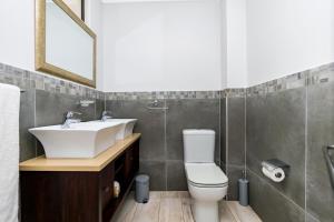 a bathroom with a sink and a toilet and a mirror at Baluwatu 10, Zimbali Estate by Euphoric Leisure in Ballito