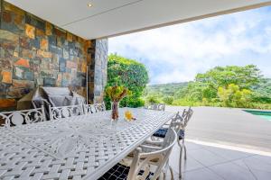 an outdoor dining table and chairs on a patio at Baluwatu 10, Zimbali Estate by Euphoric Leisure in Ballito