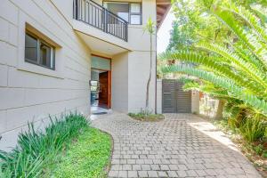 a house with a brick walkway in front of it at Baluwatu 10, Zimbali Estate by Euphoric Leisure in Ballito