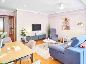 a living room with a blue couch and a tv at Zorrilla - by Wehomes in Santander