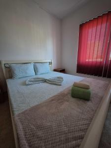 een slaapkamer met een groot bed en een rood raam bij Vila Republicii - Eforie Nord Centru in Eforie Nord