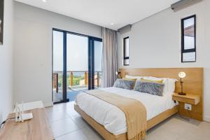 ein Schlafzimmer mit einem großen Bett und einem großen Fenster in der Unterkunft Oceans Edge 13, Zimbali Estate by Euphoric Leisure in Ballito + 46 Fotos