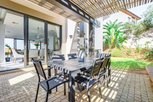 ein Esstisch und Stühle auf einer Terrasse in der Unterkunft Oceans Edge 13, Zimbali Estate by Euphoric Leisure in Ballito