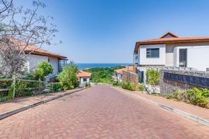eine Backsteinstraße in einem Wohnviertel mit Häusern in der Unterkunft Oceans Edge 13, Zimbali Estate by Euphoric Leisure in Ballito