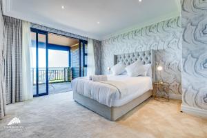 a bedroom with a large bed and a balcony at Phezulu Villas 2, Zimbali Estate by Euphoric Leisure in Ballito +42 photos
