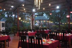 a dining room with red tables and chairs and lights at Bình Sơn Hotel - Khách sạn tại Dung Quất in Bình Sơn