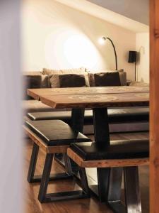 a wooden table and stool in a living room with a couch at Luxury Larch Loft in Tesido
