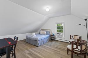a bedroom with a bed and a desk and a window at 19 Malden 3Br Apt on 2F with WIFi and Free parking with Windows AC in Malden