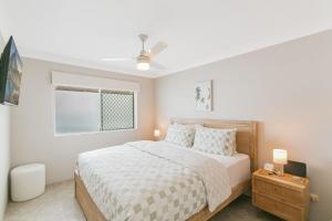 Un dormitorio blanco con una cama y una ventana. en By The C, en Gold Coast