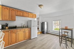 a kitchen with wooden cabinets and a white refrigerator at 19 Malden 3Br Apt on 2F with WIFi and Free parking with Windows AC in Malden