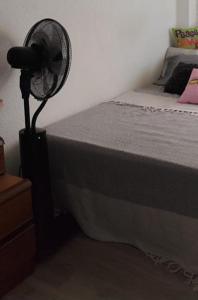 a bedroom with a fan next to a bed at Quarto por temporada in Rio de Janeiro