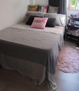 a bed with two pillows on it in a room at Quarto por temporada in Rio de Janeiro