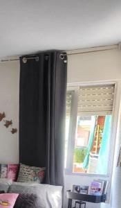 a bedroom with a black curtain and a window at Quarto por temporada in Rio de Janeiro