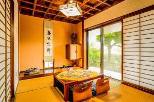 a dining room with a table and chairs and a window at Peace Branch in Yonabaru