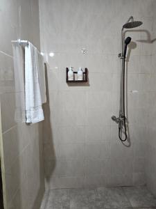 a bathroom with a shower with white towels at Vivi Cafe B&B in Zanzibar City
