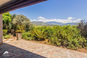 an outdoor patio with a view of the mountains at Aleah, Cathkin Estates by Euphoric Leisure in Champagne Valley
