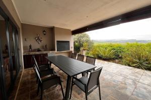 a table and chairs on a patio with a view at Aleah, Cathkin Estates by Euphoric Leisure in Champagne Valley