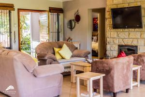 a living room with couches and a stone fireplace at Aleah, Cathkin Estates by Euphoric Leisure in Champagne Valley