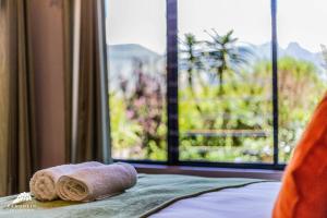 a pair of towels on a bed with a window at Aleah, Cathkin Estates by Euphoric Leisure in Champagne Valley