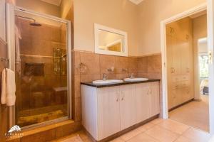 a bathroom with two sinks and a shower at Aleah, Cathkin Estates by Euphoric Leisure in Champagne Valley