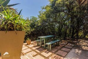a green picnic table sitting on a patio at Aleah, Cathkin Estates by Euphoric Leisure in Champagne Valley