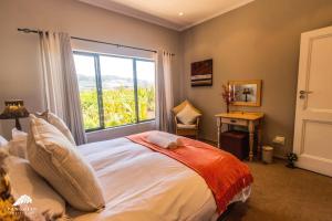 a bedroom with a bed with a large window at Aleah, Cathkin Estates by Euphoric Leisure in Champagne Valley