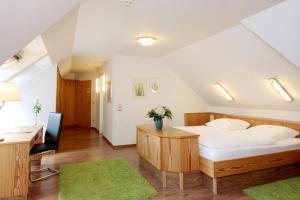 a bedroom with a large bed and a desk and a chair at Ringhotel Fährhaus in Bad Bevensen