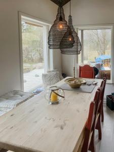 una sala da pranzo con un tavolo di legno con sedie e finestre di Cozy Modern Cabin In West Norway With View a Davik