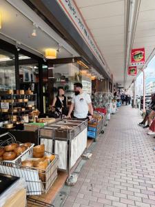 two men are preparing food in a bakery at househotel上野 入谷 in Tokyo