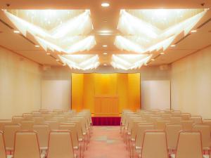 an empty lecture hall with chairs and a yellow screen at ANA Crowne Plaza Resort Appi Kogen by IHG in Hachimantai