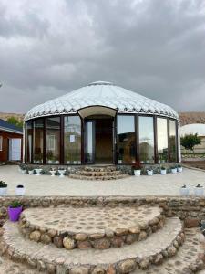a large glass building with a circle in front of it at Tasmal Yurt Camp in Tong