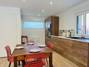 a kitchen with a wooden table with chairs and a dining room at Maison de charme entre CABOURG et CAEN in Bavent