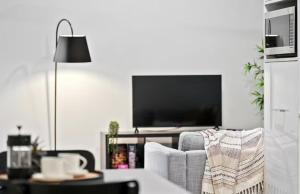 Una sala de estar con un sofá y un televisor. en The Perfect Location Gym, Pool & Parking M22, en Brisbane