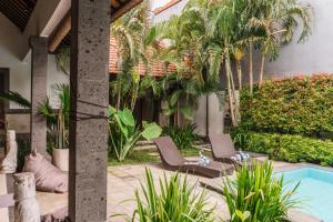a courtyard with two chairs and a swimming pool at Villa Linda, Canggu, 3BR Pool, 3 min to FINNS in Canggu