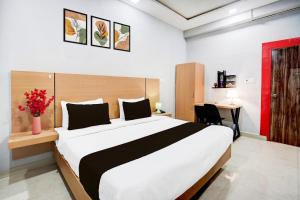 a bedroom with a large white bed and a desk at Collection O Hotel Krrish Resto in Bhilai