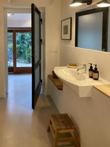 a bathroom with a sink and a mirror and a stool at Beach House With Sauna By Norsminde Harbour in Malling