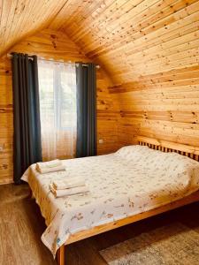 a bedroom with a bed in a wooden room at Tasmal Yurt Camp in Tong