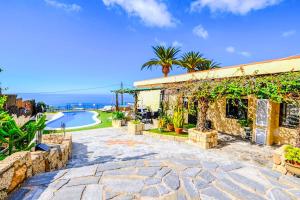a stone house with a patio and a swimming pool at Villa Isabel Sol in Adeje