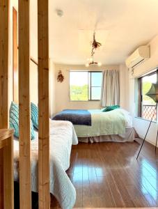 Un dormitorio con dos camas y una ventana. en 民泊宿 i s e s h i m a 伊勢内宮前203, en Ise