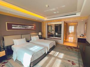 a hotel room with two beds and a window at Wanda Realm Dandong in Dandong