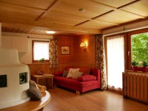a living room with a red couch and a window at Haus Thussn, Ferienwohnung für Familien und Paare in Kirchberg in Tirol