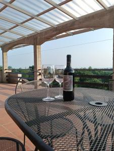 a bottle of wine sitting on a table with two wine glasses at Casa Lodolo Lessona in Lessona